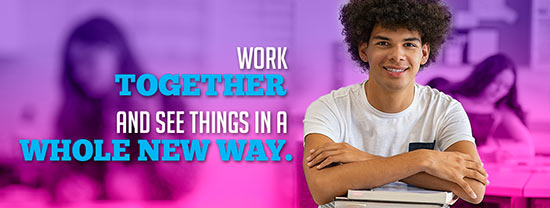 Work together and see things in a whole new way. (Simling student looking at camera with books)